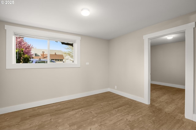 empty room featuring wood finished floors and baseboards