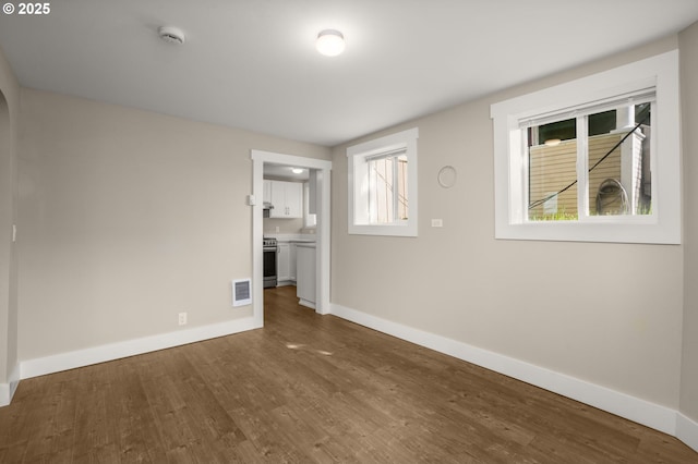 interior space with baseboards, visible vents, and dark wood finished floors