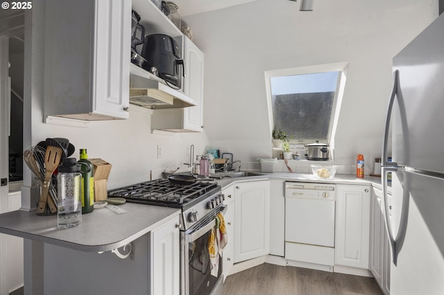 kitchen with dark wood-type flooring, freestanding refrigerator, white cabinets, stainless steel range with gas stovetop, and dishwasher