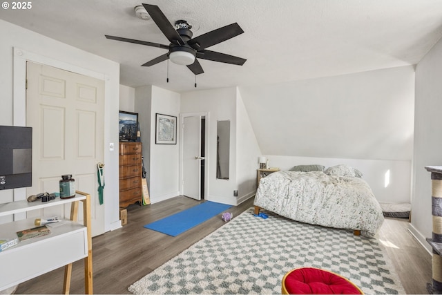 bedroom featuring vaulted ceiling, wood finished floors, a ceiling fan, and baseboards