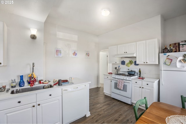 kitchen with white appliances, arched walkways, white cabinets, dark wood-style floors, and under cabinet range hood