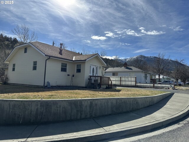 346 N Humbolt St, Canyon City, OR 97820 - view of side of home with fence, a mountain view, and a yard