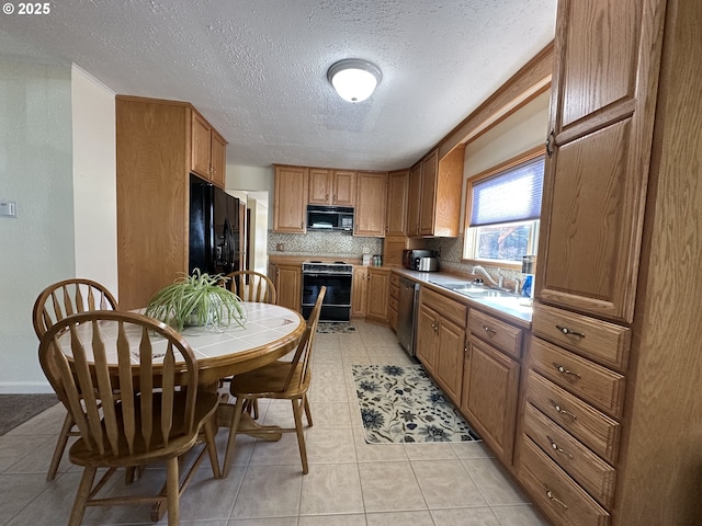 346 N Humbolt St, Canyon City, OR 97820 - kitchen with decorative backsplash, a sink, light tile patterned flooring, black appliances, and brown cabinets