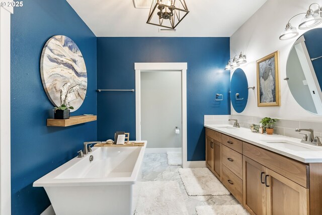 14015 NE 52nd Ave, Vancouver, WA 98686 - bathroom featuring a soaking tub, marble look tiles, double vanity, a chandelier, and baseboards