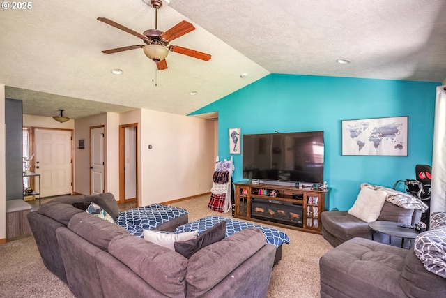 carpeted living room with a ceiling fan, vaulted ceiling, baseboards, and a textured ceiling