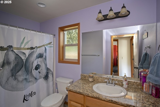 bathroom featuring vanity, toilet, and curtained shower
