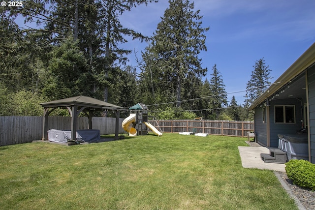 view of yard featuring a gazebo, a covered hot tub, and a playground