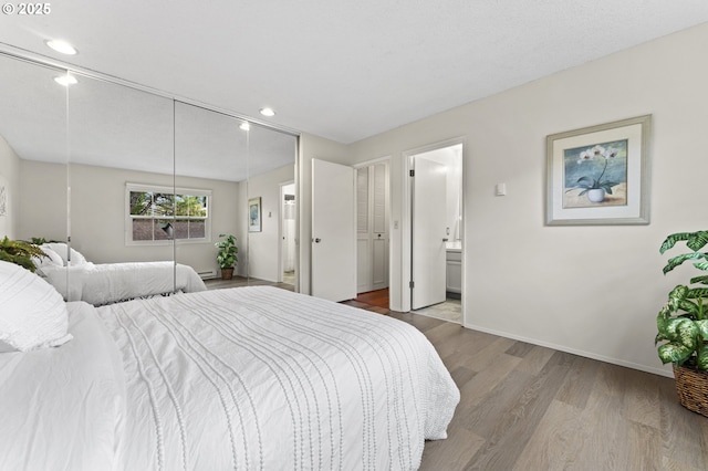 bedroom featuring connected bathroom and wood-type flooring