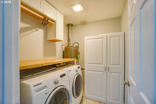 laundry room featuring gas water heater, cabinets, and washing machine and clothes dryer