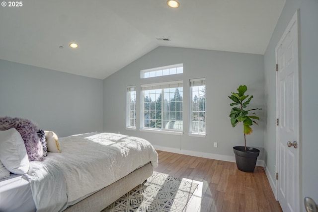 bedroom with vaulted ceiling and light hardwood / wood-style floors