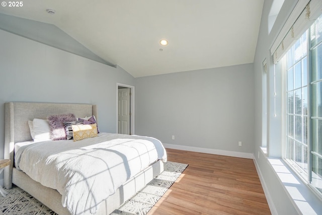 bedroom with lofted ceiling and light hardwood / wood-style floors