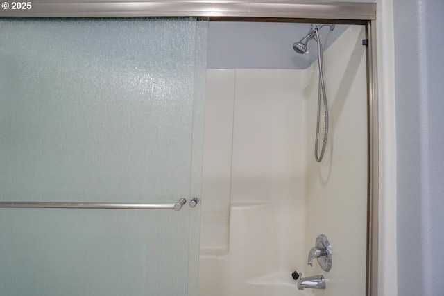 bathroom featuring combined bath / shower with glass door