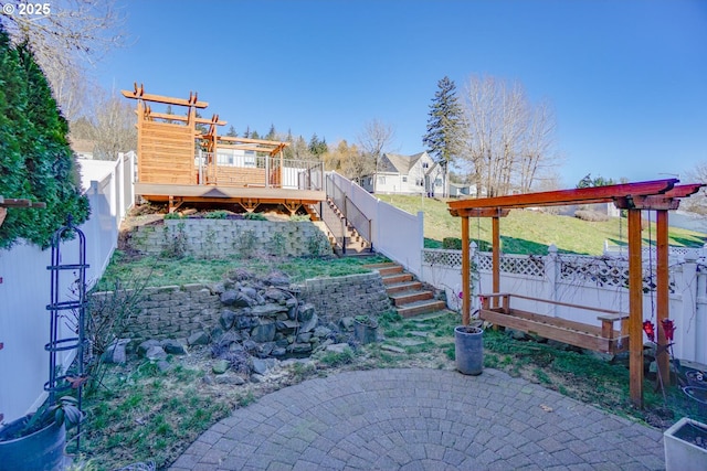 view of yard featuring a wooden deck and a patio