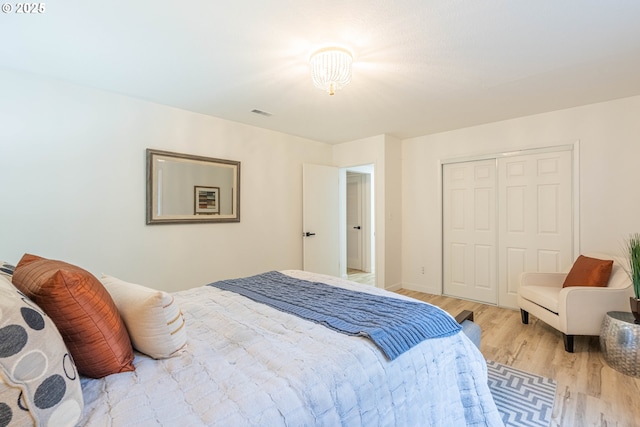 bedroom with light wood-type flooring and a closet