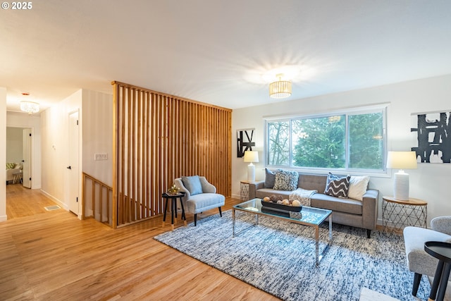 living room with an inviting chandelier and wood-type flooring