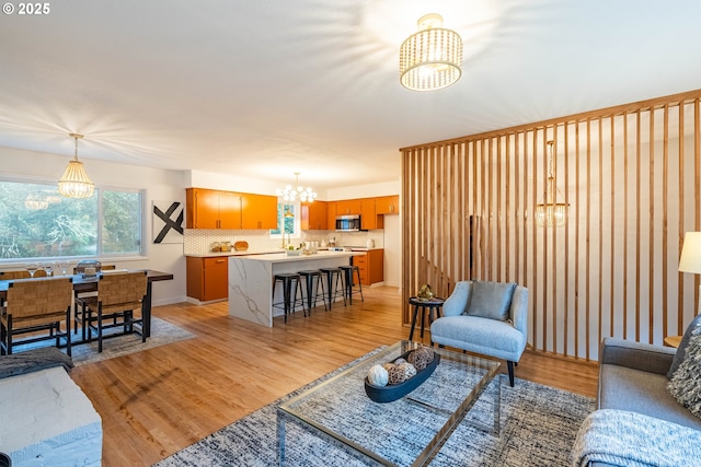 living room with light wood-type flooring and a notable chandelier