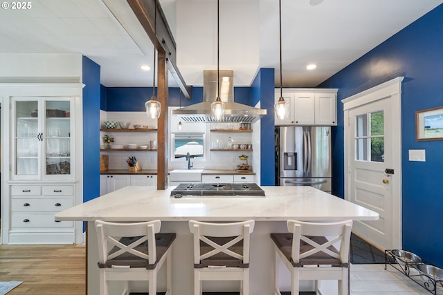 233 SE 28th Ave, Portland, OR 97214 - kitchen featuring appliances with stainless steel finishes, open shelves, tasteful backsplash, white cabinetry, and wall chimney range hood