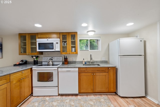 233 SE 28th Ave, Portland, OR 97214 - kitchen with white appliances, a sink, light wood-style floors, brown cabinets, and glass insert cabinets