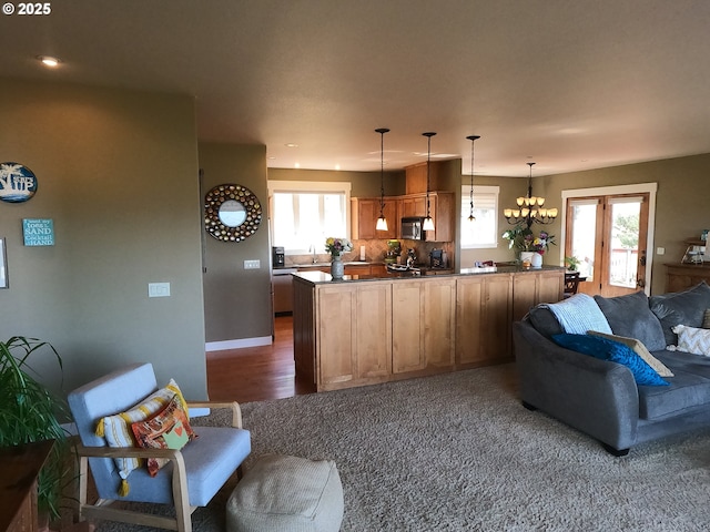 kitchen with open floor plan, stainless steel microwave, dark countertops, and a wealth of natural light