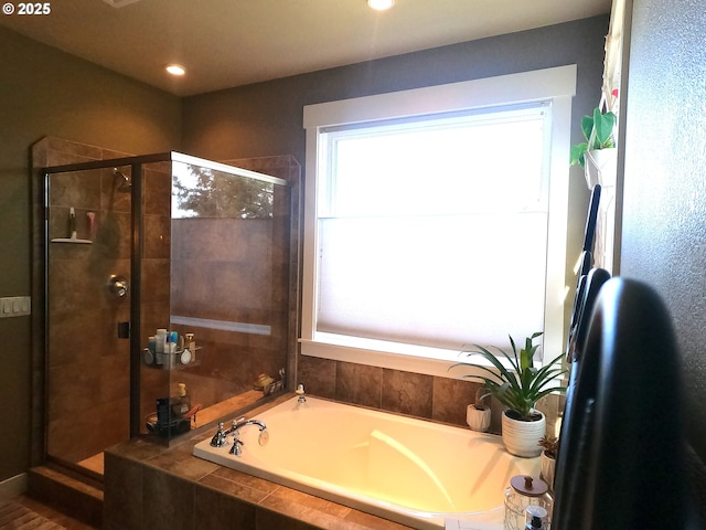 bathroom featuring a garden tub and a shower stall