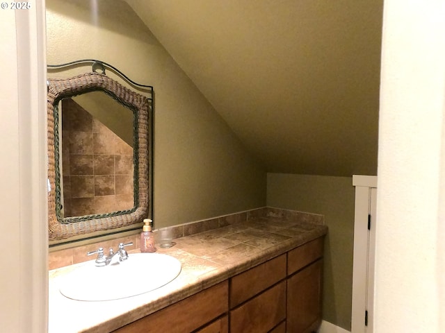 bathroom featuring vaulted ceiling and vanity