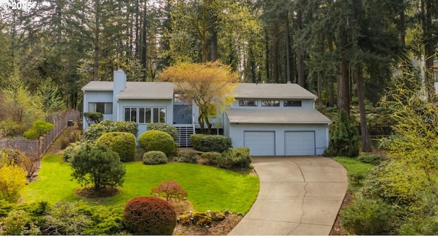 view of front facade featuring an attached garage, a chimney, driveway, and stucco siding