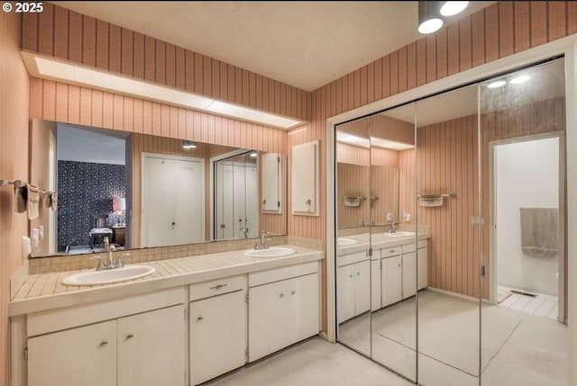 full bathroom featuring double vanity, wallpapered walls, and tile patterned flooring