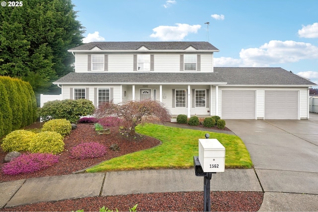 traditional home with a front lawn, concrete driveway, a garage, and a shingled roof