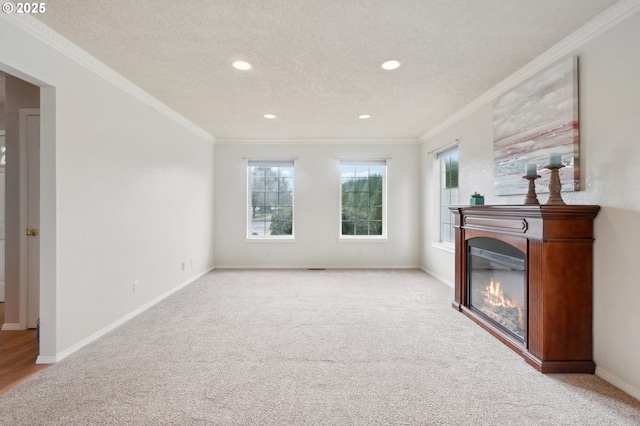 living area featuring a glass covered fireplace, crown molding, a textured ceiling, and baseboards