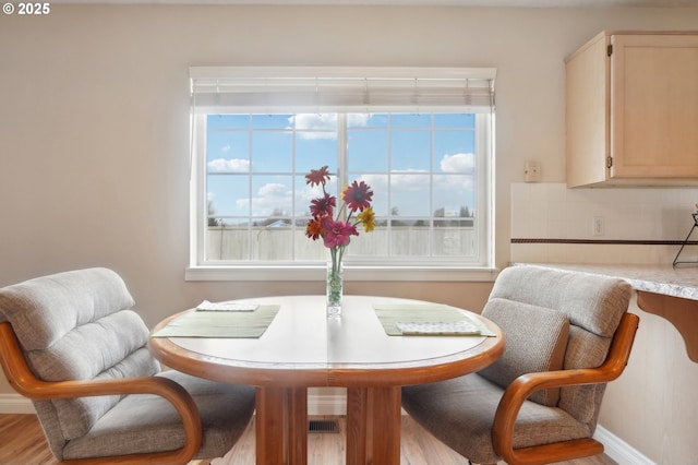 dining area with baseboards and wood finished floors