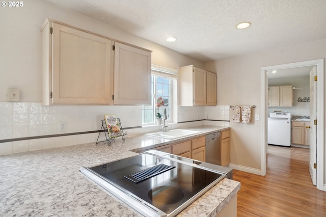 kitchen with light countertops, backsplash, stainless steel dishwasher, stove, and washer / dryer