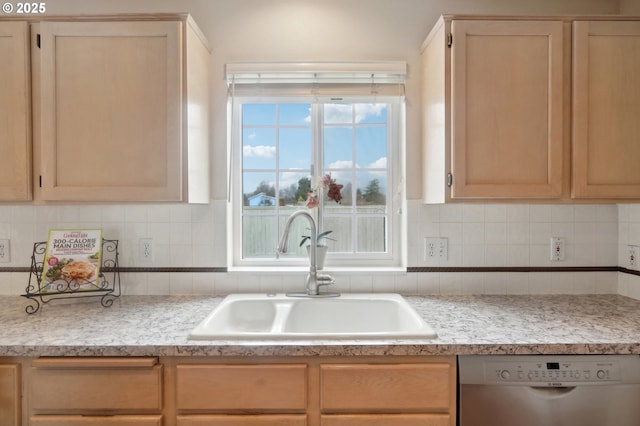 kitchen with dishwasher, light countertops, tasteful backsplash, and a sink