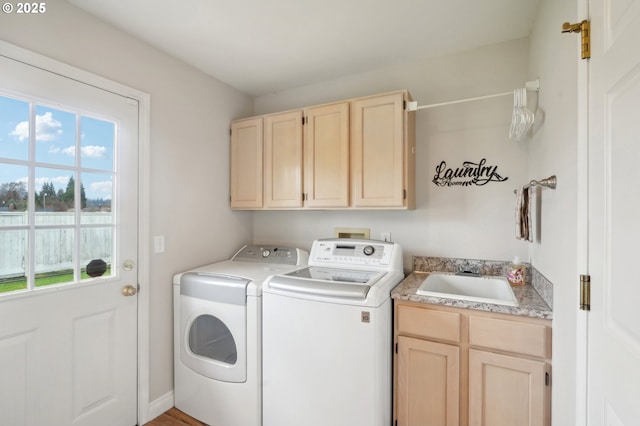 laundry area featuring a wealth of natural light, a sink, cabinet space, and washer and dryer