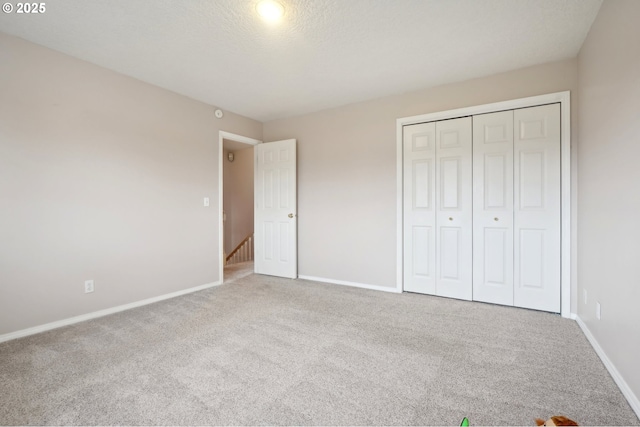 unfurnished bedroom with carpet, baseboards, and a closet