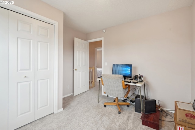 carpeted office space featuring baseboards