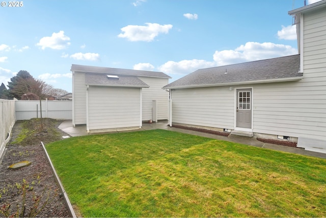 back of property with a fenced backyard, a vegetable garden, a lawn, and roof with shingles