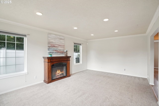 unfurnished living room with ornamental molding, a glass covered fireplace, carpet floors, and recessed lighting