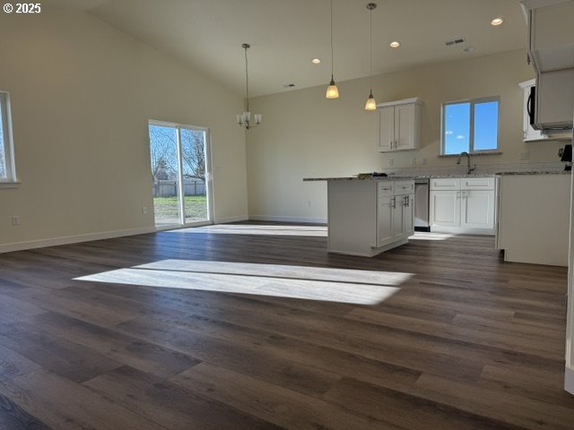 kitchen featuring dark hardwood / wood-style floors, plenty of natural light, white cabinetry, and hanging light fixtures