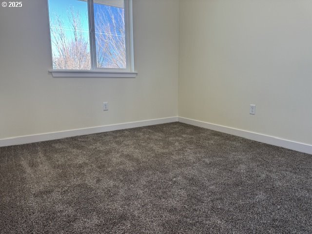 unfurnished room featuring dark carpet