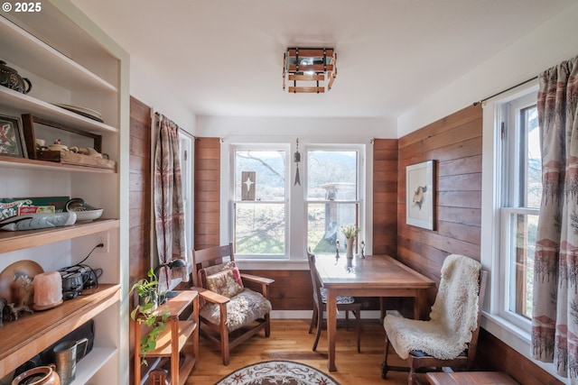 dining space with wooden walls and light hardwood / wood-style floors