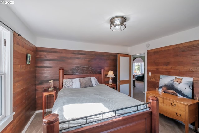 carpeted bedroom featuring wooden walls