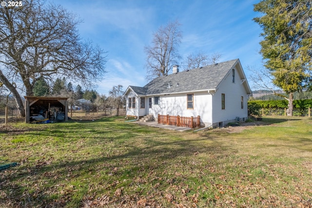 back of house featuring a lawn and a carport