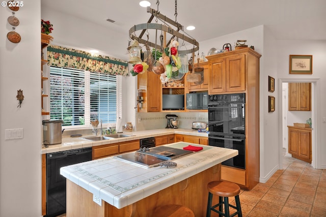 83485 Clear Lake Rd, Florence, OR 97439 - kitchen with black appliances, tile counters, decorative backsplash, a kitchen island, and recessed lighting