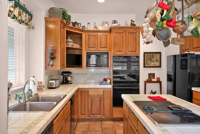 83485 Clear Lake Rd, Florence, OR 97439 - kitchen with tile countertops, black appliances, decorative backsplash, brown cabinets, and light tile patterned floors