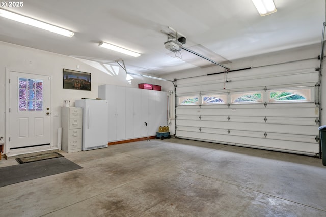 83485 Clear Lake Rd, Florence, OR 97439 - garage featuring freestanding refrigerator and a garage door opener