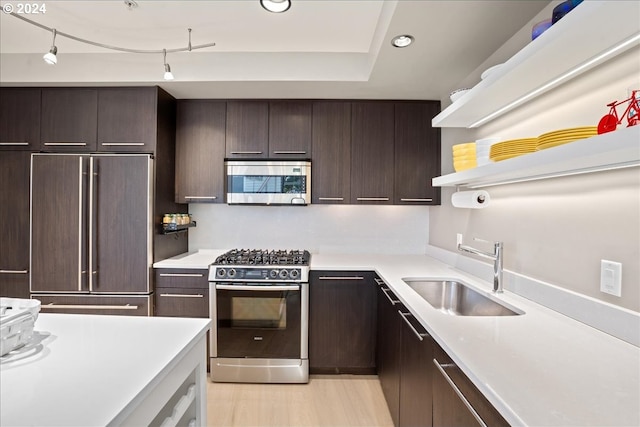 kitchen featuring track lighting, stainless steel appliances, dark brown cabinets, and sink