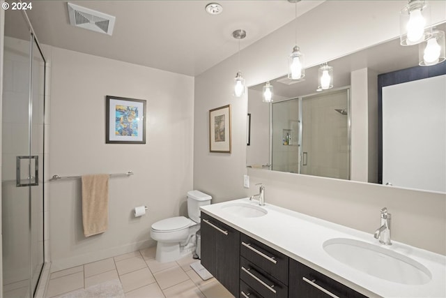 bathroom featuring toilet, tile patterned floors, an enclosed shower, and vanity