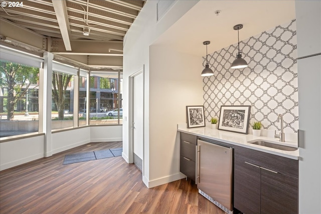 kitchen featuring fridge, sink, dark hardwood / wood-style flooring, beamed ceiling, and dark brown cabinets