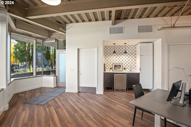 unfurnished office featuring dark wood-type flooring and beamed ceiling