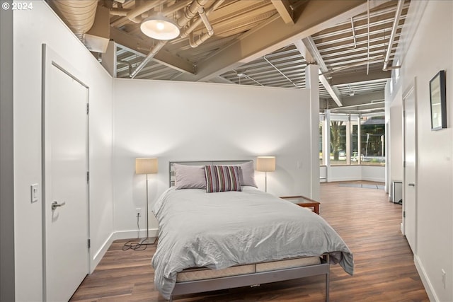 bedroom with dark hardwood / wood-style floors